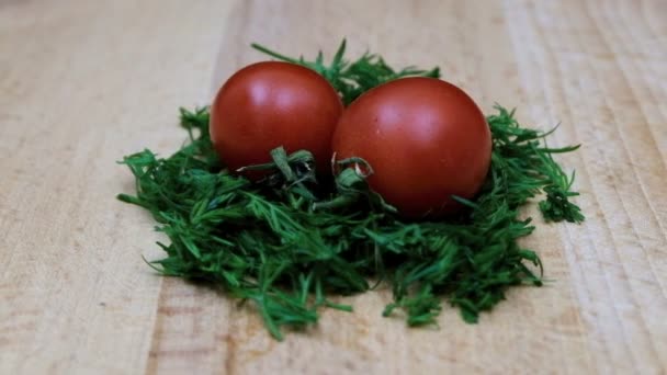 deux tomates rouges couchées dans une salade qui tourne lentement devant la caméra 