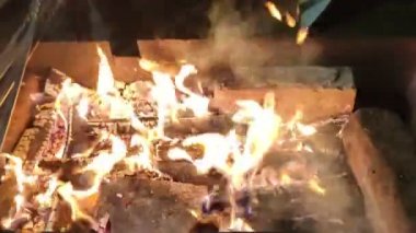Karanlıkta barbekü hazırlığı için ızgarada odun yakmak.