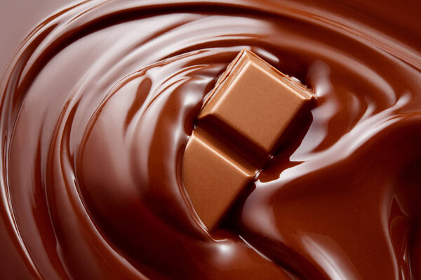 Chocolate background. Chocolate bar in hot melted chocolate. Stock Image