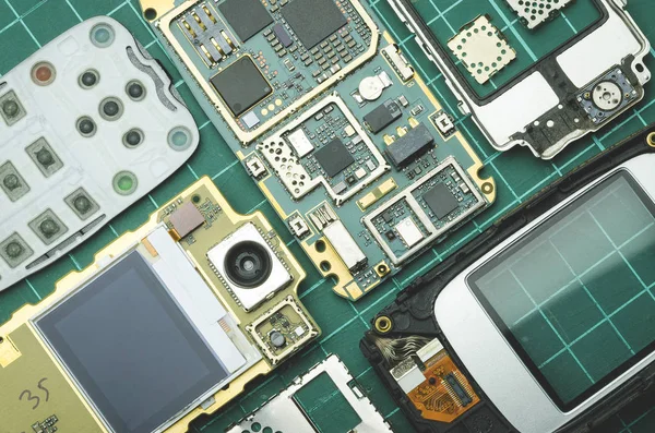 yedek parça eski cep telefonu üzerinde yeşil arka plan yakın çekim için tasfiye