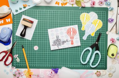 DIY renkli kağıt, ev yapımı kartpostal ve yeşil mat kesme, üstten görünüm, ellerimi için araçlarda scrapbooking yaptı