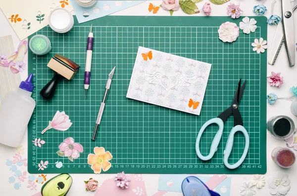 yeşil kesme mat, araçları ve scrapbooking malzemeleri, üstten görünüm, ellerimi ev yapımı kartpostal