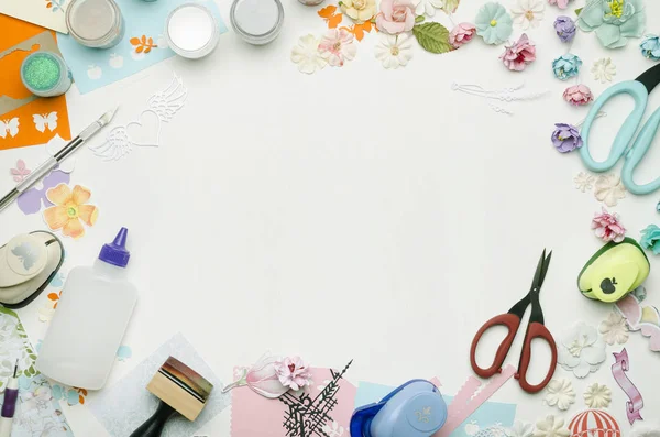 Kağıt çiçekler, çok renkli kağıt ve scrapbooking malzemeleri çevrili merkezi boş boşluk. Üstten görünüm