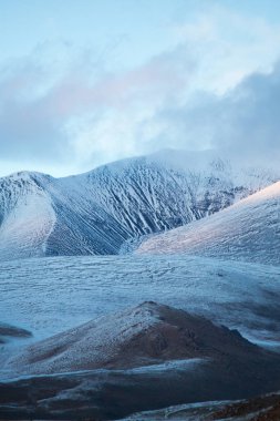 Zirveleri karla kaplı tepelerin mavi tonlarında