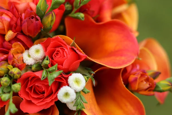 Part of an orange bouquet of callas and roses