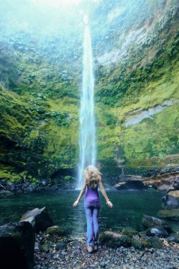 Onu geri karşı kamp giysili şelale ile kız duruyor