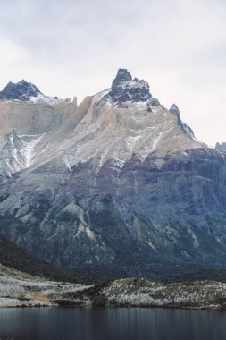 Şili. Torres del Paine. Dramatik manzara. Hızlı dağ nehir kayaların arasında karla kaplı dağlar arka planı geçiyor..