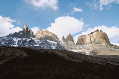 Şili. Torres del Paine. Dramatik manzara. Hızlı dağ nehir kayaların arasında karla kaplı dağlar arka planı geçiyor..