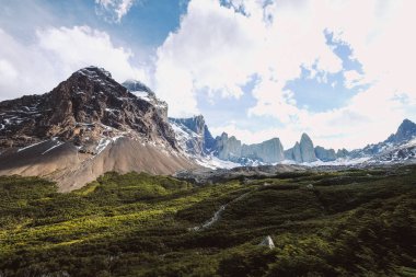 Şili. Torres del Paine. Dramatik manzara. Hızlı dağ nehir kayaların arasında karla kaplı dağlar arka planı geçiyor..