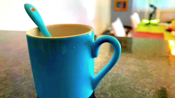 A close-up of a blue mug on a table of an appartment