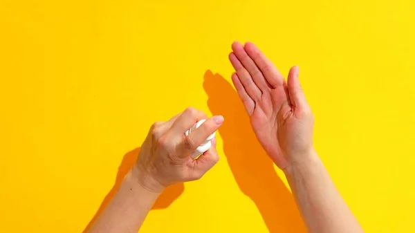 Hände Einer Frau Die Ein Spray Auf Gelbem Hintergrund Benutzt — Stockfoto