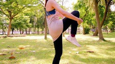 Parkta egzersiz yapan bir kadının bedeni.