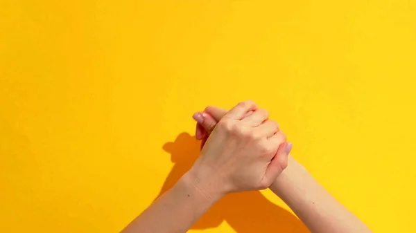 Foto Una Mujer Que Frota Las Manos Sobre Fondo Amarillo — Foto de Stock