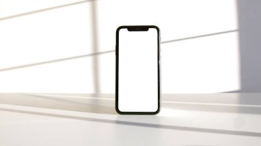 Beyaz bir arkaplanda akıllı bir telefona yakın çekim.