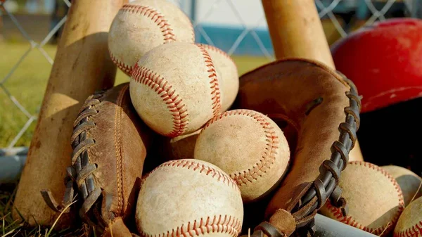 A close up on balls, a glove and bats of baseball