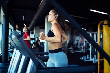 Spor salonunda koşu bandında koşan kadın. Sağlıklı yaşam için egzersiz yapmak..