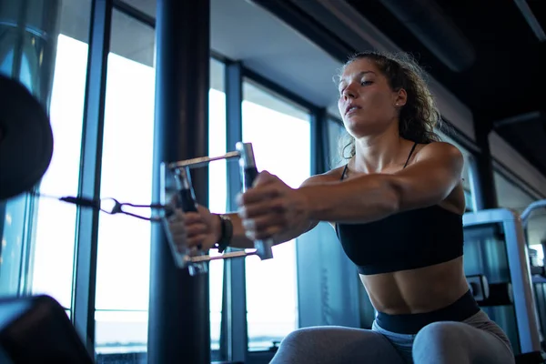 Female exercising in the gym. Bodybuilding and training in fitness center.