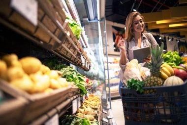 Kadın öğle yemeği için alışveriş yapıyor. Kadın süpermarketten sağlıklı yiyecekler almaktan hoşlanır..