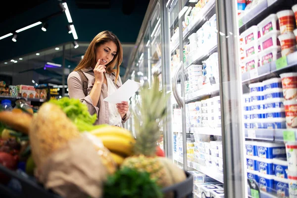 Una Donna Premurosa Nella Lista Dei Supermercati Che Legge Articoli — Foto Stock