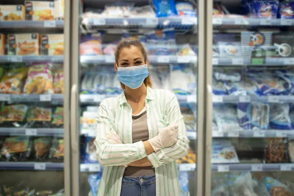 Süpermarkette koruyucu maskeli ve eldivenli bir kadının portresi markette yemek maskesinin yanında duruyordu. Coronavirüs veya COVID-19 'u durdurun..