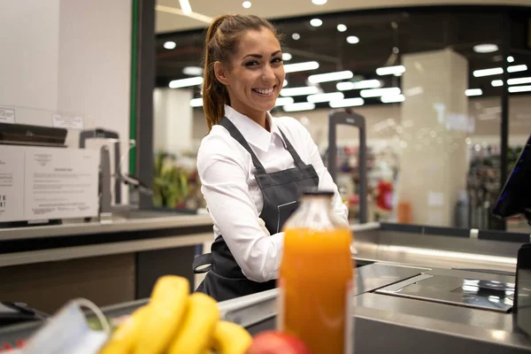 Portrait of female cashier in supermarket. Job position.
