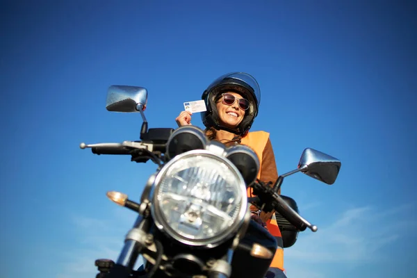 Motosiklet sürme okulu ve kurslar. Miğferli ve yansıtıcı yelekli bir öğrenci sınıfta motosiklet sürüyor..