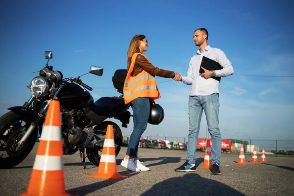 Motosiklet sürüş kursu. Ders başlamadan önce öğretmen ve öğrenci tokalaşması. Motosiklet sürmek için güvenli sürüş dersleri.