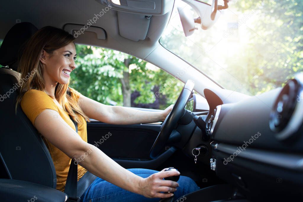 Car interior view of female driver enjoys driving a car. Woman driving automobile.