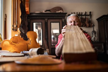 Sanat ve el sanatları. Kıdemli marangoz işten önce tahta kalitesini kontrol ediyor. Eski moda marangoz atölyesinde ahşap işçisi..