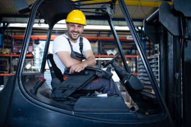 Fabrika deposundaki profesyonel forklift sürücüsünün portresi..