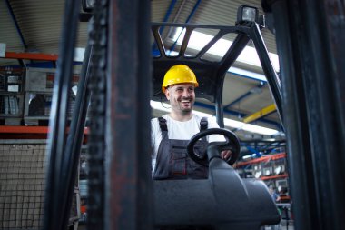 Fabrikanın deposunda forklift kullanan profesyonel bir işçi..