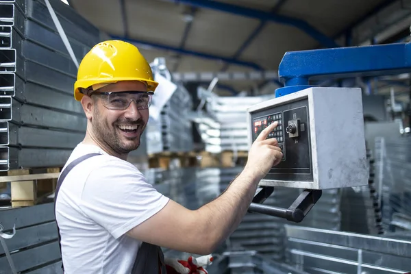 Fabrika işçisinin portresi endüstriyel makine çalıştırıyor ve parametreleri bilgisayarda ayarlıyor.