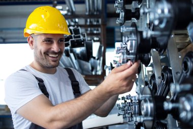 Fabrikadaki üretim bandında çalışan sanayi işçisi.