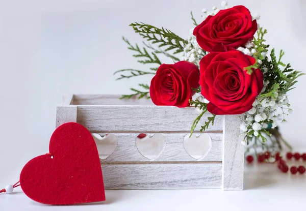 Röda rosor i en trälåda med ett känt hjärta Royaltyfria Stockfoton