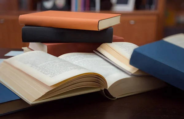 Flera öppna och slutna böcker på träbord — Stockfoto