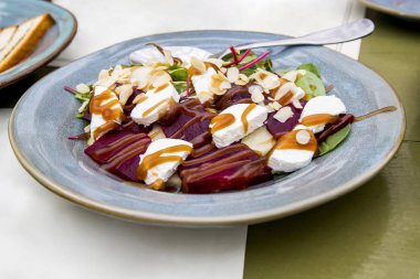 Keçi peyniri salatası. Keçi peyniri, pişmiş armut, kırmızı pancar, roach, mangold, badem ince tabakalar, tatlım köfte