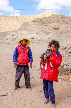 Bir Berber çocuk yanında onun elinde bir keçi ile parlak elbiseleri yalınayak kız Berberka. Mısır, Taba, 20 Şubat 2015