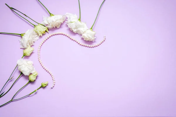 Parel Kralen Witte Bloemen Een Paarse Achtergrond Van Bovenaf Bekijken — Stockfoto