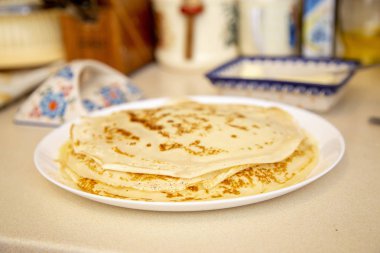 Krepler beyaz bir plaka üzerinde bir tereyağı yemek yanındaki masada