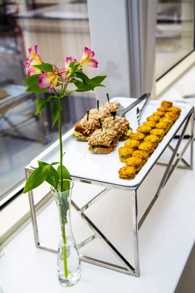 mini tarts with champignons and mini burgers with fried mackerel, tartar sauce, fresh cucumber and ice salad at catering event on some festive event, party or wedding reception