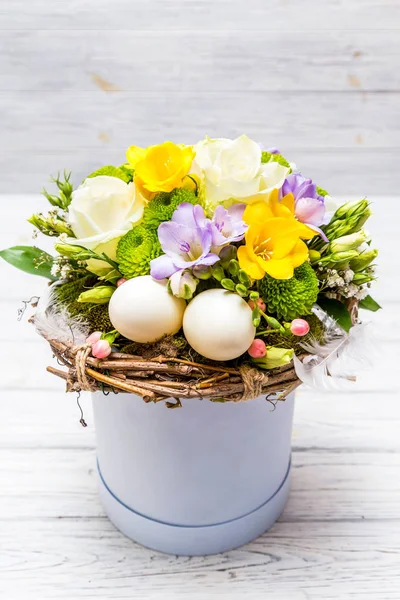 Easter Arrangement Flowers Eggs Cylindrical Blue Box Light Wooden Background — Stock Photo, Image