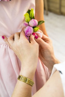 eller zarif çiçek dekorasyon düğün partide genç kız için ekleyin. Şakayık tomurcukları kızın dres üzerinde butanniere