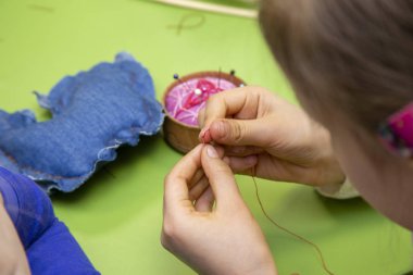 Bir ders ya da bir dikiş Atölyesi - çocuk eller bir iğne iplik