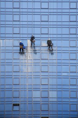 3 erkek yüksek, kentsel modern inşaat ve tehlikeli işgal yansıtılmış pencereleri yıkayın