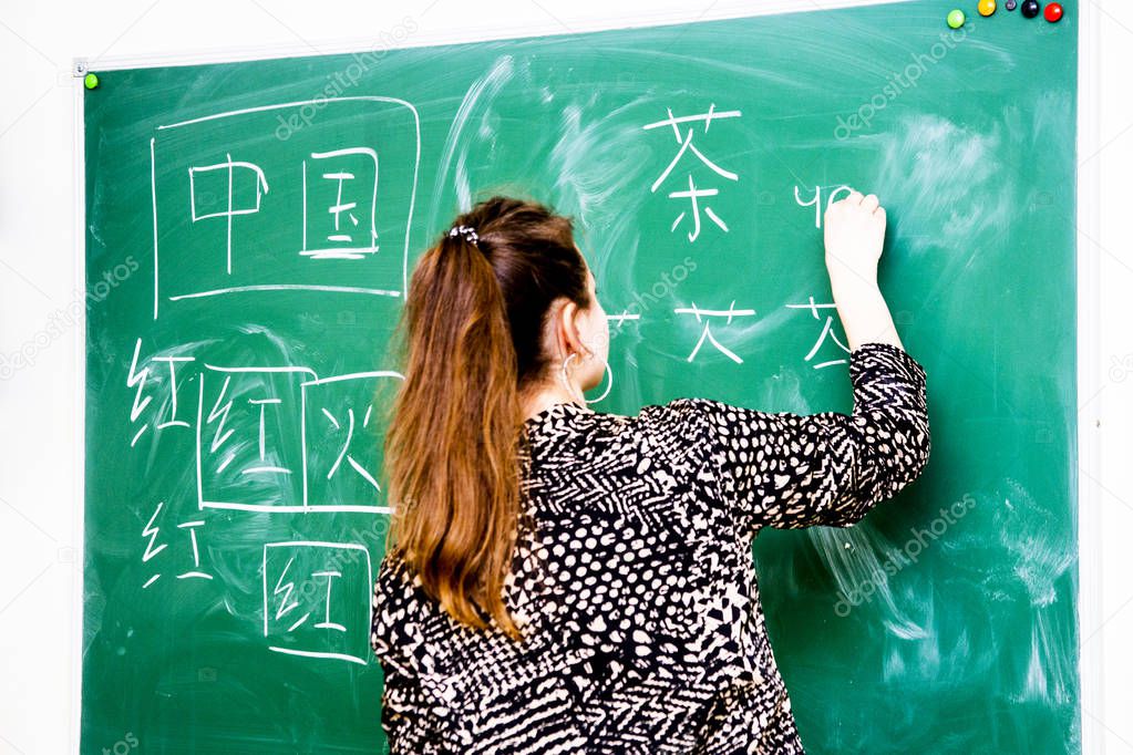 the teacher near the school board writes Chinese characters