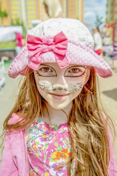 Portret van meisje in roze kleding met een kitten gezicht schilderen — Stockfoto