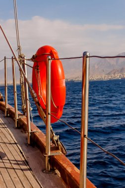 Lifebuoy güneşli bir günde denize karşı iskele yakınında asılı