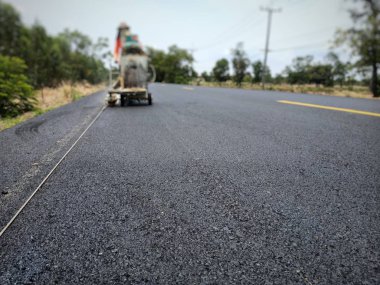 Teknisyenler asfalt yüzeyinde ki trafik hatları üzerinde çalışıyor.