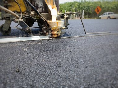 Teknisyenler asfalt yüzeyinde ki trafik hatları üzerinde çalışıyor.