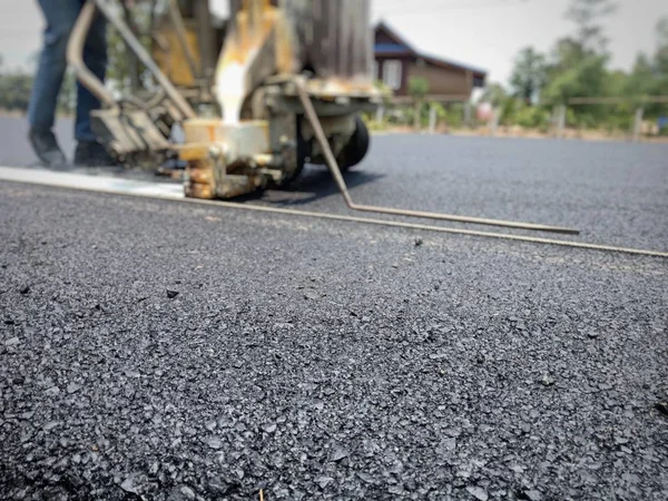 Teknisyenler asfalt yüzeyinde ki trafik hatları üzerinde çalışıyor.
